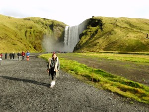 Berdiri di depan Skógafoss Waterfall Iceland dengan latar air terjun megah dan panorama alam