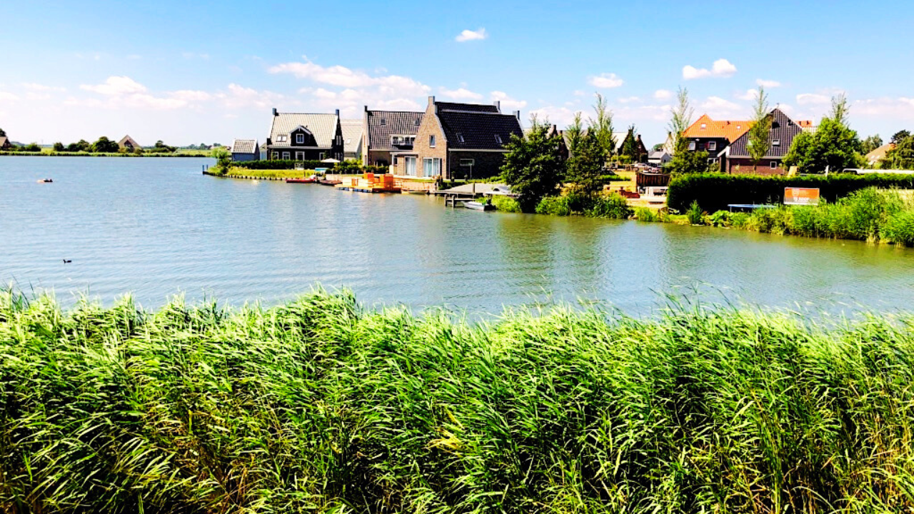 Deretan rumah kayu tradisional Belanda di atas tanggul atau dijk pinggir danau Volendam