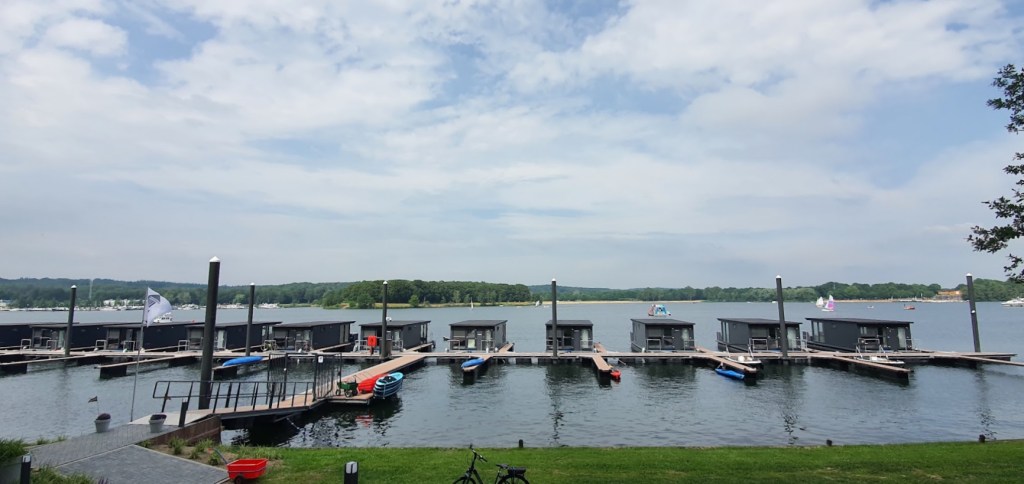 Pemandangan sungai di Millingen aan de Rijn, dengan bangku kayu kosong di tepi dermaga