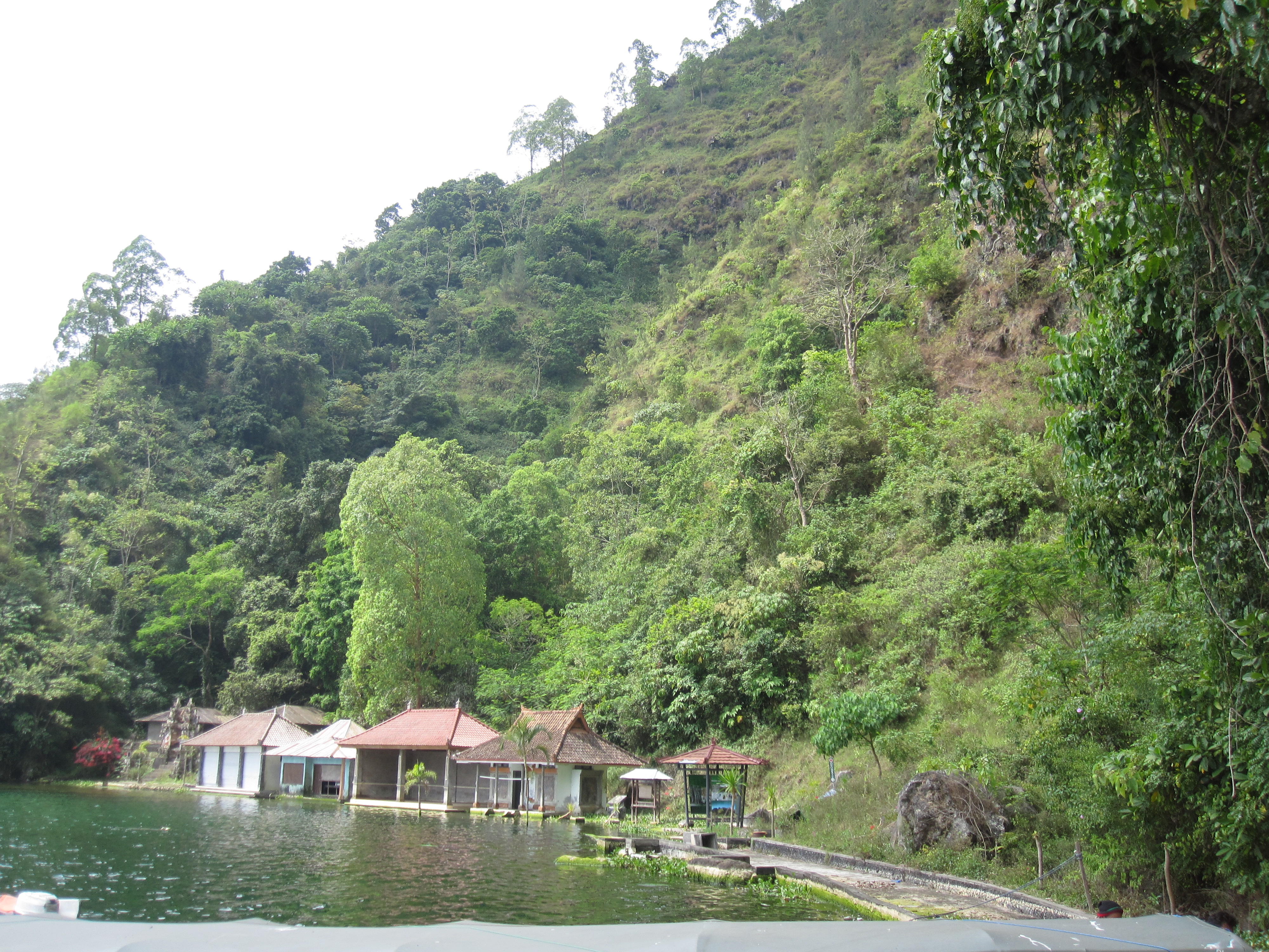 Panorama rumah-rumah tradisional Suku Bali Aga di Desa Trunyan di tepi Danau Batur, menunjukkan arsitektur dan kehidupan sehari-hari warga lokal
