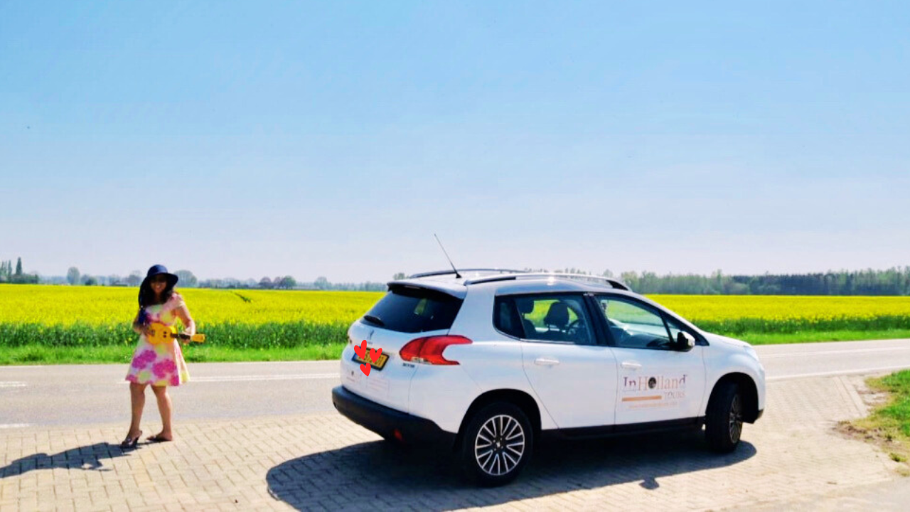 Elly Afriani bersama kendaraan operasional berlatar ladang lobak indah di Belanda, memberikan panduan profesional aturan sewa bus Eropa dan biaya checkpoint Venesia 2026.