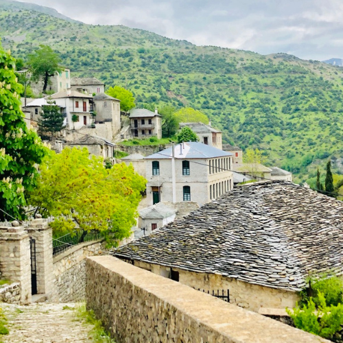 Pemandangan magis Desa Syrrako di pagi hari. Seluruh bangunan dan atapnya terbuat dari batu tulis, dengan menara Gereja Ortodoks yang berdiri megah di tengah lembah Pegunungan Tzoumerka. Sebuah desa yang seolah berhenti di masa lalu.