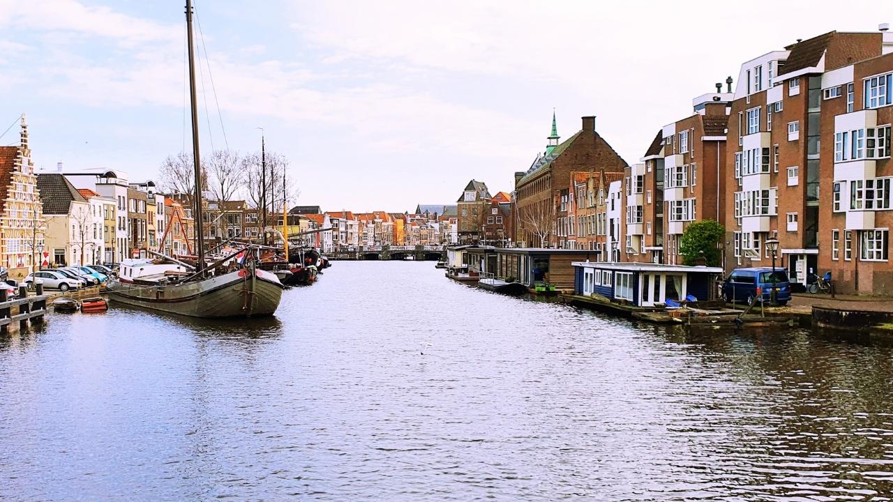 Kapal wisata menyusuri kanal Leiden Belanda dengan deretan rumah warga di tepi air
