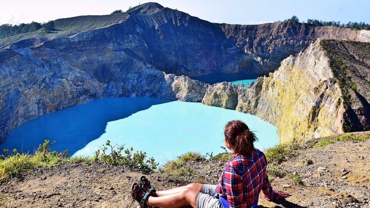 Elly Afriani duduk menikmati panorama Danau Kelimutu Flores
